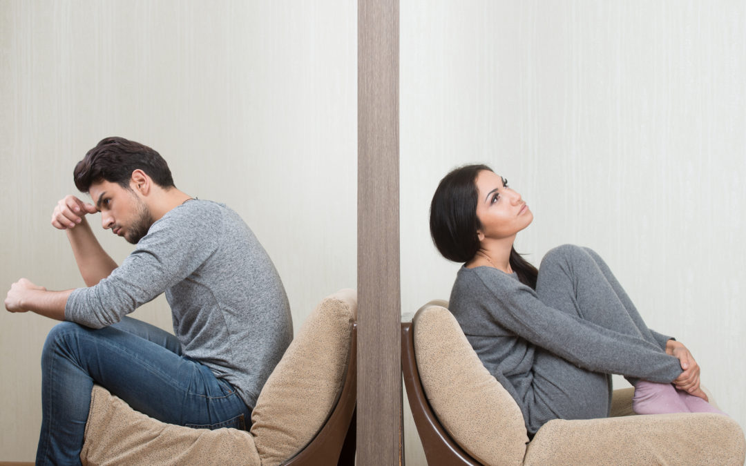 Conflict between man and woman sitting on either side of a wall